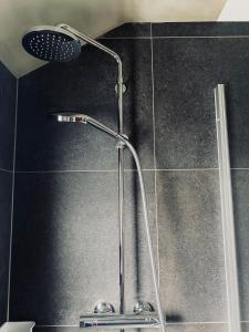 a shower with a shower head in a bathroom at PHOENIX Apartments - Monteurwohnung mit RIESIGER Parkfläche in Bielefeld
