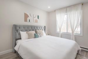 1 dormitorio blanco con 1 cama blanca grande con almohadas en The Olympic Stadium Cozy 2 king size beds en Montreal