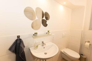 biała łazienka z umywalką i toaletą w obiekcie Haus Helga w mieście Salzkotten