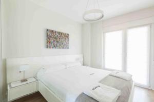 扎魯亞斯的住宿－EGONA- ZU9B Espectacular apartamento，一间白色卧室,配有一张床和一幅画