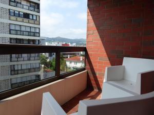 扎魯亞斯的住宿－EGONA- ZU9B Espectacular apartamento，阳台配有白色椅子和砖砌建筑