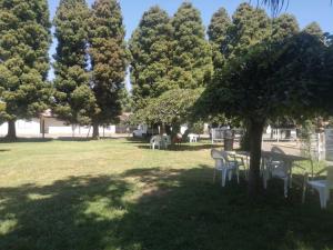 a picnic table and chairs in a park with trees at Hotel Sol de Alicante in Los Ángeles