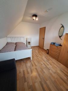 una camera con letto bianco e pavimento in legno di FEWO Dümmer-Diepholz1 a Diepholz