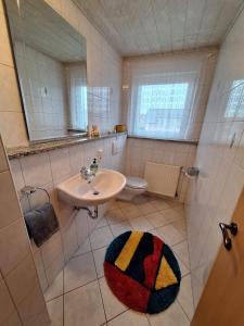 bagno con lavandino, servizi igienici e specchio di FEWO Dümmer-Diepholz1 a Diepholz