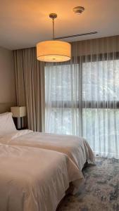 a bedroom with a bed and a large window at Luxury the address 3BR in Fujairah