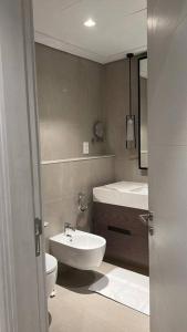 La salle de bains est pourvue d'un lavabo blanc et de toilettes. dans l'établissement Luxury the address 3BR, à Fujaïrah