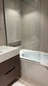 La salle de bains est pourvue d'une douche, d'une baignoire et d'un lavabo. dans l'établissement Luxury the address 3BR, à Fujaïrah