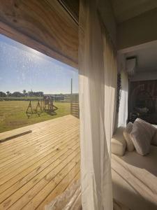 ein Schlafzimmer mit einer Holzterrasse und einem großen Fenster in der Unterkunft Tribeka House in Islote