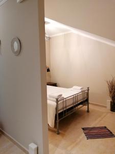 - une chambre dotée d'un lit avec des draps blancs dans l'établissement Marinos Studios - 2nd floor studio, à Poros