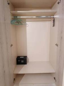 a white closet with a black appliance on a shelf at Marinos Studios - 2nd floor studio in Póros Kefalonias