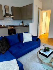 Stylish One Bedroom Apartment in the heart of Angel في لندن: أريكة زرقاء في غرفة المعيشة مع طاولة