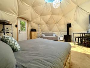 - une chambre avec un grand lit dans une tente dans l'établissement Vallée Jeunesse Québec, à Saint-Gabriel-de-Valcartier