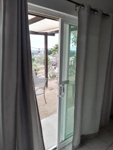 eine Glasschiebetür mit Strandblick in der Unterkunft Rancho Matalote en Valle de Guadalupe in Valle de Guadalupe