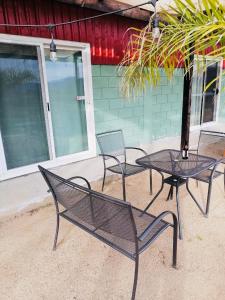 un grupo de sillas y una mesa frente a un edificio en Rancho Matalote en Valle de Guadalupe en Valle de Guadalupe