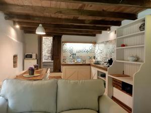 a living room with a couch and a kitchen at Granja Labrada: Alojamiento con caballos in Mañón