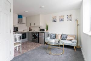 ein Wohnzimmer mit einem Sofa und einem Tisch in der Unterkunft 1 Bedroom Apartment - Netflix - Close To City Centre And NEC in Birmingham