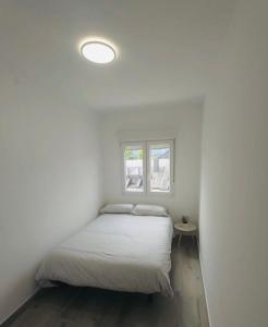 Posto letto in una camera bianca con finestra di Descubre Cantabria! Piso con 3 habitaciones, con capacidad hasta 5 personas! Alojamiento entero! a Sarón
