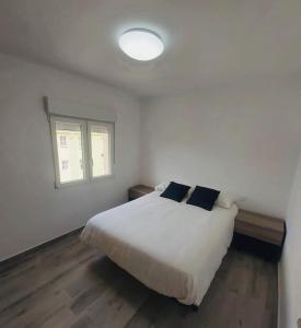 una camera con un letto bianco e una finestra di Descubre Cantabria! Piso con 3 habitaciones, con capacidad hasta 5 personas! Alojamiento entero! a Sarón