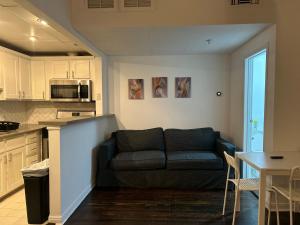 sala de estar con sofá y cocina en Chic Urban Retreat - 5 Mins to LACMA Lights, en Los Ángeles