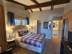 a bedroom with a bed with a plaid blanket at Boundary Waters Resort & Marina in Hiawassee