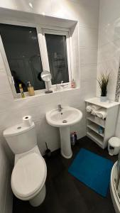 a white bathroom with a toilet and a sink at Nyza's cosy House in Blackpool