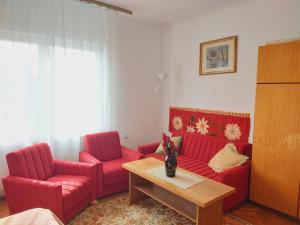 a living room with two red couches and a coffee table at Nagyiék háza / Granny's House in Esztergom +34 photos