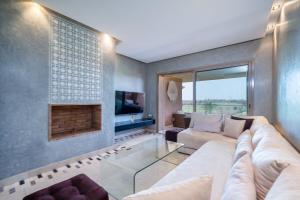 a living room with a couch and a fireplace at Vue Imprenable golf-Piscine in Marrakesh