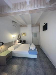 a bedroom with a large white bed and a flat screen tv at Diaporos Hotel in Vourvourou