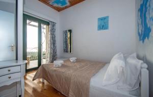 a white bedroom with a bed and a window at Villa Voula in Koiliomenos