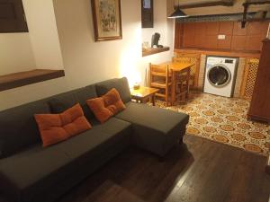 a living room with a green couch with orange pillows at Casa del Cantaor in Granada