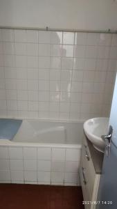 y baño con bañera blanca y lavamanos. en Charmant appartement T2 de 36m² au cœur du village, en Saintes-Maries-de-la-Mer