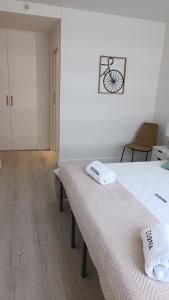 a white room with a bed with towels on it at Egona - SAL14 Apartamento en nueva zona residencial en Zarautz in Zarautz