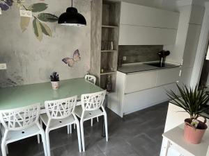 cocina con mesa verde y sillas blancas en Apartamento moderno y acogedor ideal familias, en Orio