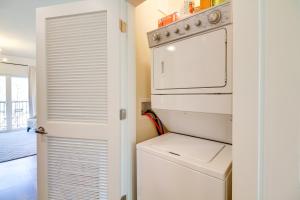 a white kitchen with a washer and dryer in it at Walkable Lynchburg Condo with Private Balcony in Lynchburg