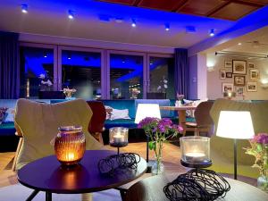 ein Wohnzimmer mit Stühlen und einem Tisch mit Kerzen in der Unterkunft Hotel Boehler in Böblingen