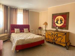 una camera con un grande letto con testiera rossa di B&B Guarini a Casamassima