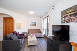 een woonkamer met een bank en een flatscreen-tv bij Ferienwohnung Rosendahl in Reit im Winkl