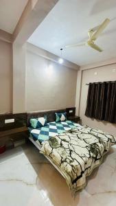 een slaapkamer met een bed en een plafondventilator bij Hotel Kanha Palace in Ujjain