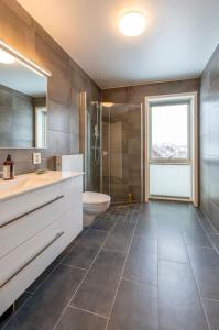 ein Bad mit einem Waschbecken, einem WC und einem Fenster in der Unterkunft Leilighet med sjøutsikt og privat takterrasse. Parkering in Svolvær