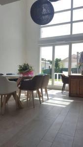 ein Esszimmer mit einem Tisch, Stühlen und einem Fenster in der Unterkunft Maison moderne proche site JO, Paris et Disneyland in Ferrières-en-Brie