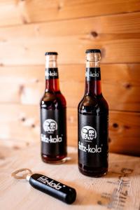 Zwei Flaschen Bier auf einem Tisch mit einer Fernbedienung. in der Unterkunft heimatbude Loft in Rotenhain