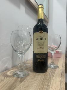 una botella de vino junto a dos copas de vino en Apartamento La Plana II, en Castellón de la Plana