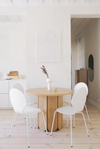 a dining room with a wooden table and white chairs at Avar ja hubane stuudiokorter kesklinnas in Viljandi