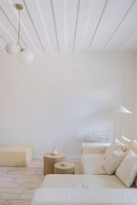 a white living room with a couch and tables at Avar ja hubane stuudiokorter kesklinnas in Viljandi