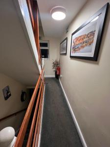 a hallway with a stairway with a painting on the wall at ABBEY HOLIDAY ACCOMMODATiON in Whitby