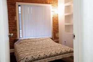 a small bedroom with a bed and a window at City Escape- 5 Mins to LACMA! in Los Angeles