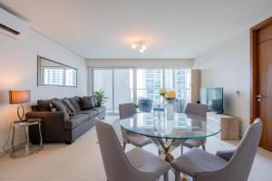 a living room with a glass table and chairs at Awesome 2BR with balcony in Costa del Este in Panama City