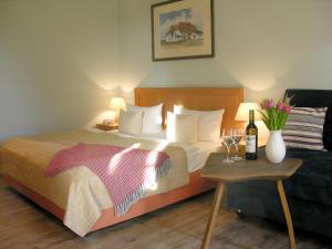 Habitación de hotel con cama y mesa con copas de vino en Hotel Enddorn Hiddensee en Kloster