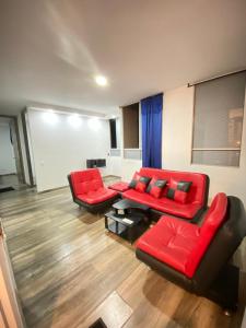 a living room with two couches and red chairs at Apartamento en Villavicencio in Villavicencio