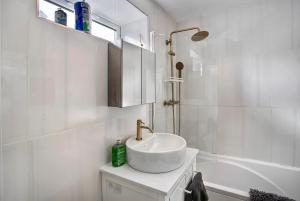 a white bathroom with a sink and a bath tub at Cozy 1Bed Apt in Central Beckton with Parking Close to London City Airport & Excel Centre in London